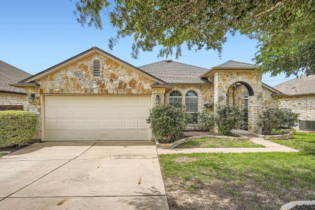 134 Sassafras St, Hutto, TX 78634 - french country home with stone siding, central AC, concrete driveway, and a garage