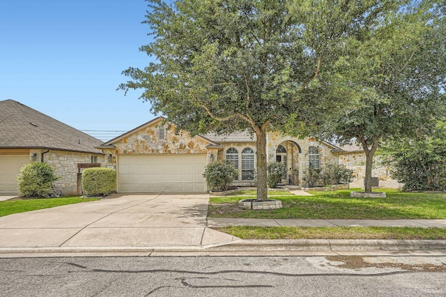 134 Sassafras St, Hutto, TX 78634 - view of front facade with stone siding, driveway, an attached garage, and a front lawn