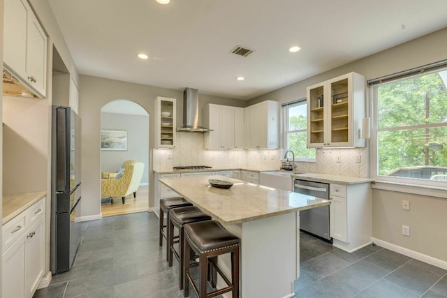 1125 Byers Ln, Austin, TX 78753 - kitchen with appliances with stainless steel finishes, wall chimney range hood, healthy amount of natural light, a kitchen breakfast bar, and recessed lighting