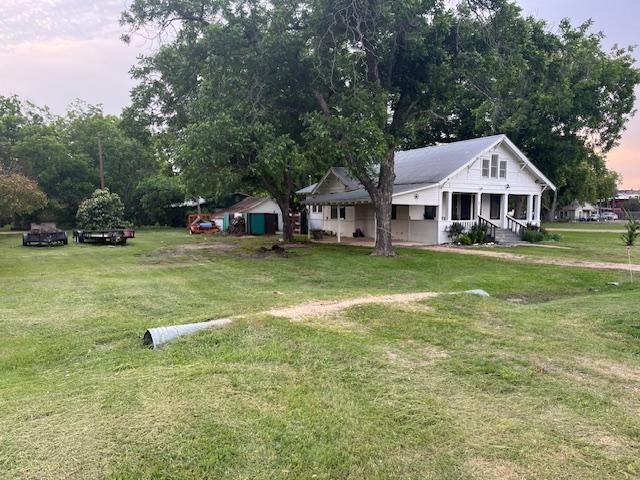 200 N Walton St, Granger, TX 76530 - view of front of home with a front yard and a shed