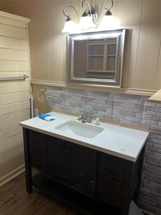 200 N Walton St, Granger, TX 76530 - bathroom with vanity, wood finished floors, tasteful backsplash, and a decorative wall