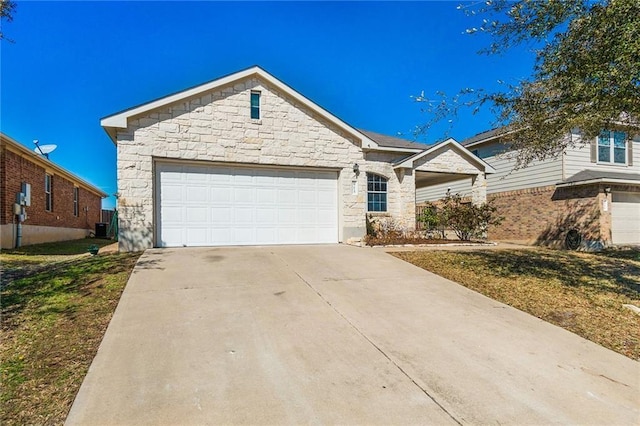 913 Cindy Ln, Leander, TX 78641 - view of front of house featuring stone siding, concrete driveway, and an attached garage