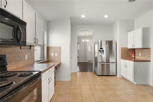 913 Cindy Ln, Leander, TX 78641 - kitchen featuring black appliances, a chandelier, white cabinetry, arched walkways, and decorative backsplash