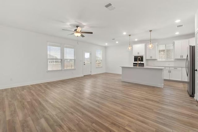 16917 Santiaguillo Trce, Manor, TX 78653 - unfurnished living room with a ceiling fan, plenty of natural light, recessed lighting, and light wood-style floors