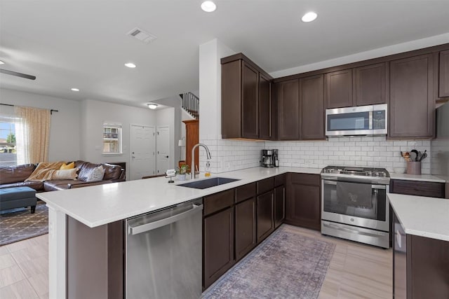 8212 Daisy Cutter Xing, Georgetown, TX 78626 - kitchen with appliances with stainless steel finishes, a sink, open floor plan, light countertops, and a peninsula