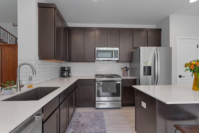 8212 Daisy Cutter Xing, Georgetown, TX 78626 - kitchen with stainless steel appliances, a sink, dark brown cabinetry, backsplash, and light stone counters