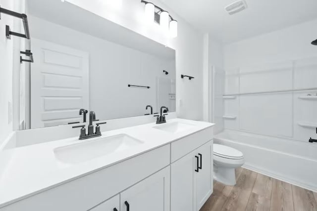 16921 Santiaguillo Trce, Manor, TX 78653 - bathroom featuring toilet, double vanity, wood finished floors, and  shower combination