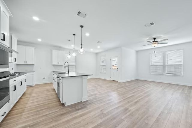 16921 Santiaguillo Trce, Manor, TX 78653 - kitchen featuring a sink, dark countertops, open floor plan, a ceiling fan, and recessed lighting