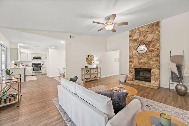 12214 Scribe Dr, Austin, TX 78759 - living area featuring a ceiling fan, light wood finished floors, a fireplace, baseboards, and recessed lighting