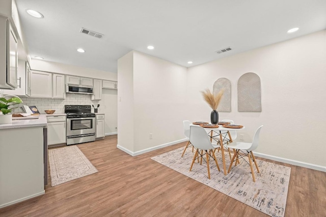 12214 Scribe Dr, Austin, TX 78759 - dining area featuring baseboards, light wood-style flooring, and recessed lighting