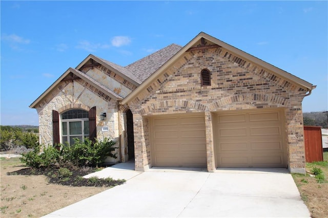 2204 Cabrillo Path, Leander, TX 78641 - french provincial home featuring a garage, concrete driveway, brick siding, and a shingled roof