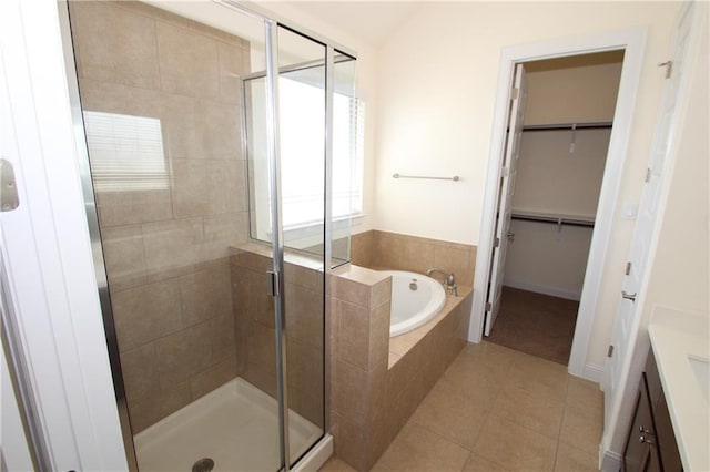 2204 Cabrillo Path, Leander, TX 78641 - bathroom with a stall shower, a garden tub, a walk in closet, tile patterned floors, and baseboards
