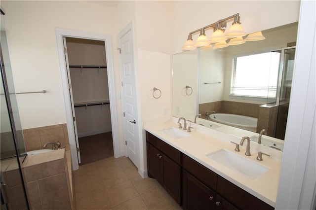 2204 Cabrillo Path, Leander, TX 78641 - bathroom with tile patterned flooring, double vanity, a garden tub, a spacious closet, and a stall shower