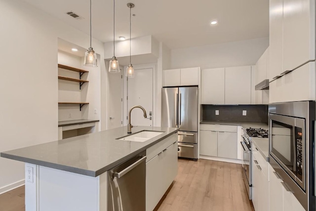 207 W Johanna Unit 108, Austin, TX 78704 - kitchen with a sink, stainless steel appliances, white cabinetry, light wood-type flooring, and decorative light fixtures