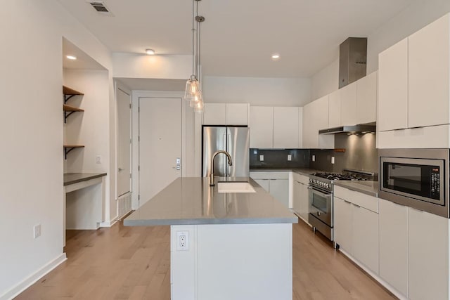 207 W Johanna Unit 108, Austin, TX 78704 - kitchen with appliances with stainless steel finishes, light wood-style floors, an island with sink, white cabinetry, and recessed lighting