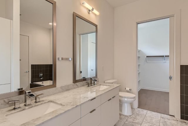 207 W Johanna Unit 108, Austin, TX 78704 - bathroom featuring toilet, marble finish floors, double vanity, and a walk in closet