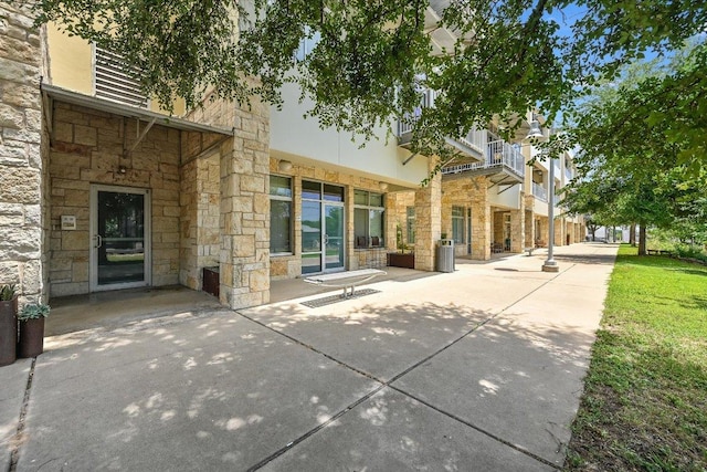 2401 E 6th St Unit 5077, Austin, TX 78702 - rear view of property featuring stone siding and a patio