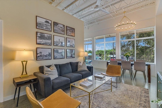 2401 E 6th St Unit 5077, Austin, TX 78702 - living area with baseboards, a towering ceiling, a chandelier, and concrete floors