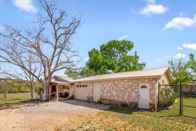 159 Baldwin Rd, Ingram, TX 78025 - view of home's exterior featuring stone siding, driveway, metal roof, and a garage
