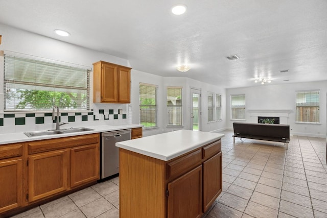 2917 Feathercrest Dr, Austin, TX 78728 - kitchen featuring stainless steel dishwasher, light countertops, decorative backsplash, a kitchen island, and a fireplace