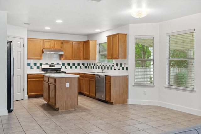 2917 Feathercrest Dr, Austin, TX 78728 - kitchen with appliances with stainless steel finishes, under cabinet range hood, light countertops, tasteful backsplash, and a center island