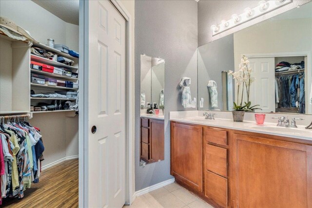 15115 Staked Plains Loop, Austin, TX 78717 - bathroom featuring double vanity, a spacious closet, and baseboards