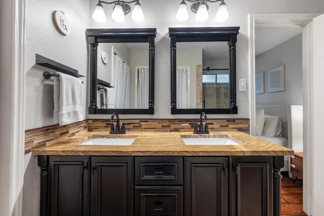 12721 Heinemann Dr, Austin, TX 78727 - full bath with tasteful backsplash, double vanity, and wood finished floors