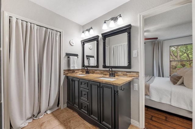 12721 Heinemann Dr, Austin, TX 78727 - ensuite bathroom featuring double vanity, backsplash, and tile patterned flooring