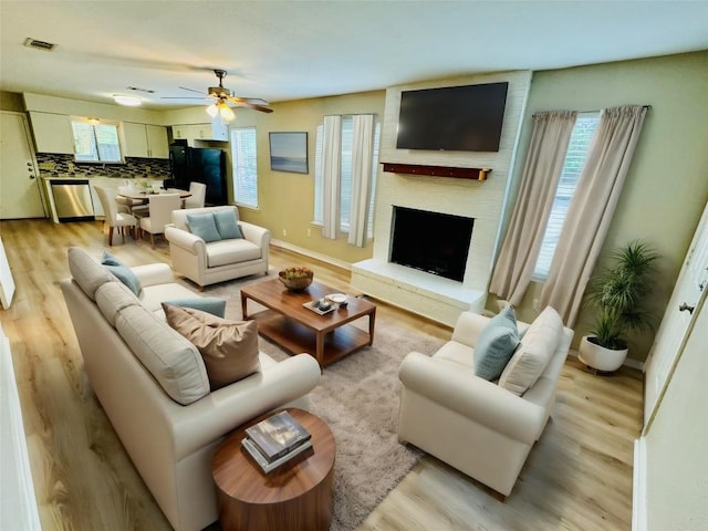 1320 Southport Dr, Austin, TX 78704 - living room with plenty of natural light, light wood-style flooring, ceiling fan, and a large fireplace