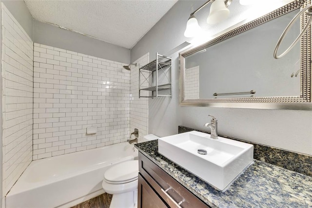 1320 Southport Dr, Austin, TX 78704 - full bath with washtub / shower combination, vanity, toilet, a textured ceiling, and wood finished floors