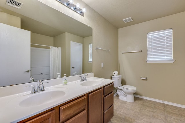 8912 Norwich Castle, Austin, TX 78747 - bathroom with double vanity, a shower with shower curtain, and tile patterned flooring