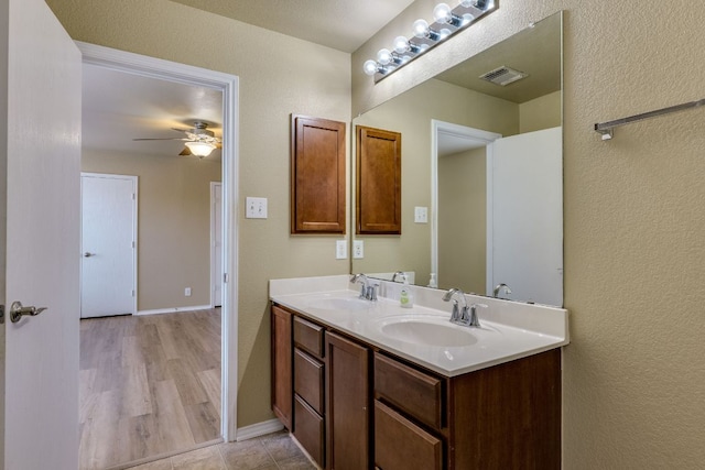8912 Norwich Castle, Austin, TX 78747 - bathroom featuring a ceiling fan, double vanity, baseboards, and a textured wall
