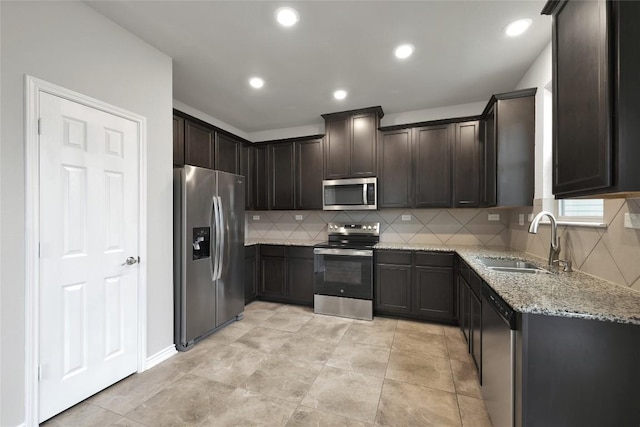 2038 Wind Chime Way, New Braunfels, TX 78130 - kitchen featuring appliances with stainless steel finishes, a sink, light stone counters, backsplash, and dark brown cabinetry