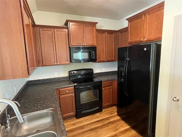 408 Azurite Dr, Jarrell, TX 76537 - kitchen with black appliances, a sink, light wood finished floors, and brown cabinetry