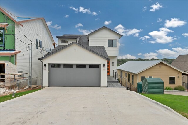 1215 Lake Shore Dr, Spicewood, TX 78669 - contemporary house with concrete driveway, a shingled roof, and an attached garage