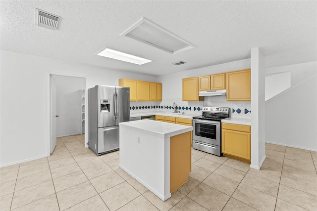 491 Emerald Fields Ln, Kyle, TX 78640 - kitchen featuring stainless steel appliances, under cabinet range hood, a sink, light countertops, and a textured ceiling