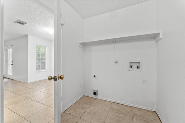 491 Emerald Fields Ln, Kyle, TX 78640 - laundry area with hookup for an electric dryer, hookup for a washing machine, light tile patterned floors, gas dryer hookup, and a textured ceiling