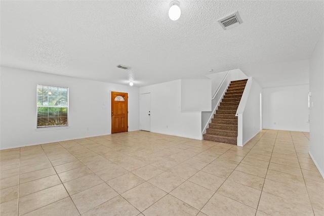491 Emerald Fields Ln, Kyle, TX 78640 - spare room with a textured ceiling, stairs, and light tile patterned floors