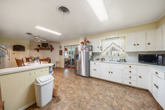704 6th St, Blanco, TX 78606 - kitchen featuring black microwave, stainless steel refrigerator with ice dispenser, a sink, light floors, and light countertops