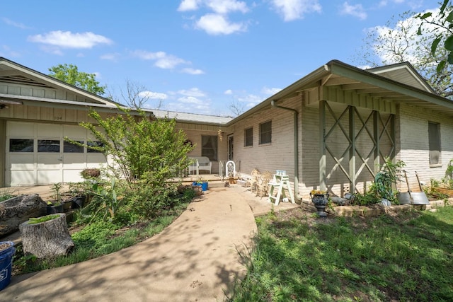 704 6th St, Blanco, TX 78606 - back of house with brick siding, a garage, and board and batten siding
