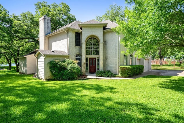 2603 Pearce Rd, Austin, TX 78730 - view of front of property with a chimney, brick siding, a front yard, and roof with shingles