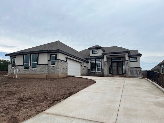 19217 Hopper Ln, Austin, TX 78738 - prairie-style house featuring a garage, stone siding, driveway, and stucco siding