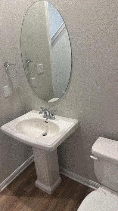 1020 Vista View Dr Unit 2001, Georgetown, TX 78626 - half bathroom with toilet, wood finished floors, baseboards, and a sink