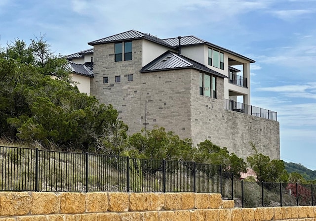 104 High View Trl, Lakeway, TX 78738 - view of property exterior with a standing seam roof, metal roof, stucco siding, and stone siding