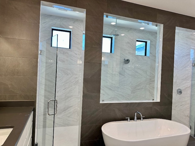 104 High View Trl, Lakeway, TX 78738 - bathroom featuring tile walls, a freestanding bath, a stall shower, and vanity