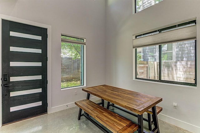 600 Blackson Ave Unit 2, Austin, TX 78752 - dining space featuring plenty of natural light, baseboards, concrete flooring, and a towering ceiling