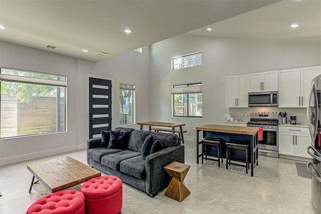 600 Blackson Ave Unit 2, Austin, TX 78752 - living room with concrete flooring, baseboards, recessed lighting, and high vaulted ceiling