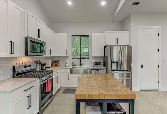 600 Blackson Ave Unit 2, Austin, TX 78752 - kitchen featuring stainless steel appliances, tasteful backsplash, white cabinets, recessed lighting, and concrete flooring