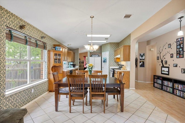 4125 Licorice Ln, Austin, TX 78728 - dining space with wallpapered walls, light tile patterned flooring, and a chandelier