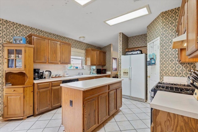 4125 Licorice Ln, Austin, TX 78728 - kitchen featuring black appliances, wallpapered walls, a kitchen island, light countertops, and light tile patterned floors